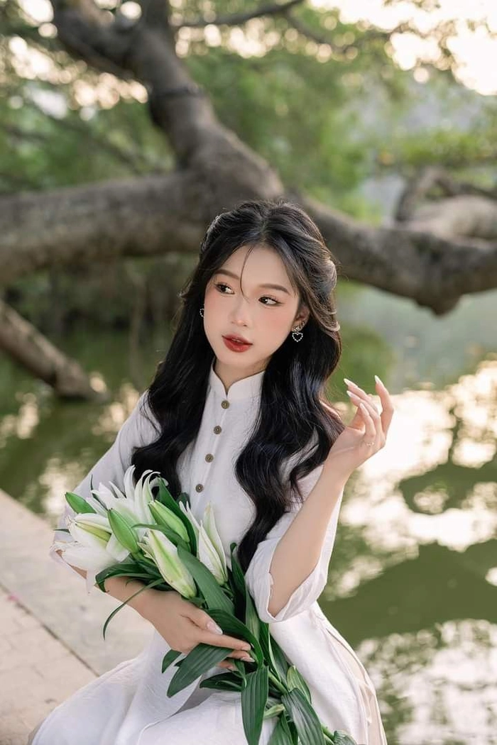Gái xinh duyên dáng tay cầm hoa